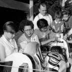 Ellen and Ted Neel and children carving a totem pole, 1955